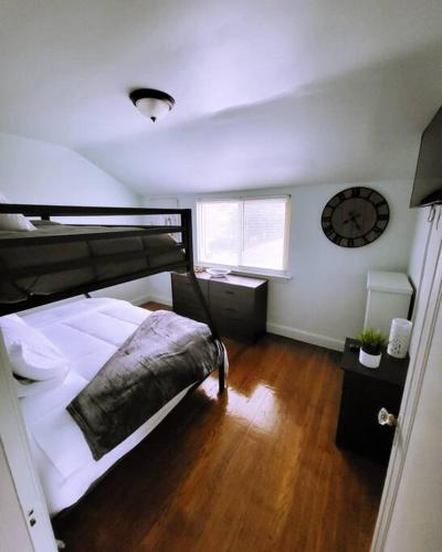 a bedroom with a bed and a clock on the wall at Vintage Charm, E. Eng. Village, 10mins to Dt. Det. in Detroit
