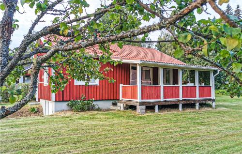 a red house with a red roof on a yard at Gorgeous Home In Sunnemo in Sunnemo