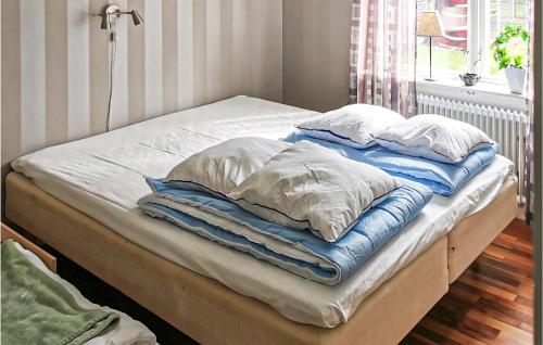 a bed with blue and white blankets and pillows at Beautiful Home In Sunnemo With Wifi And 2 Bedrooms in Sunnemo