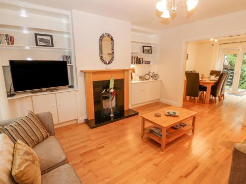 a living room with a couch and a tv and a table at No 4 Lansdowne Village in Kenmare