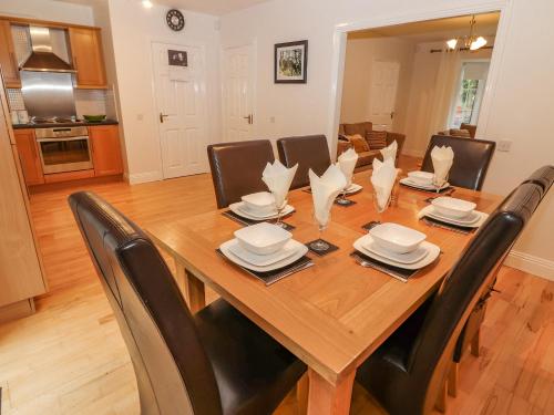a wooden dining room table with black chairs and a table and chairsktop at No 4 Lansdowne Village in Kenmare