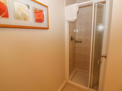 a bathroom with a shower with a glass door at No 4 Lansdowne Village in Kenmare