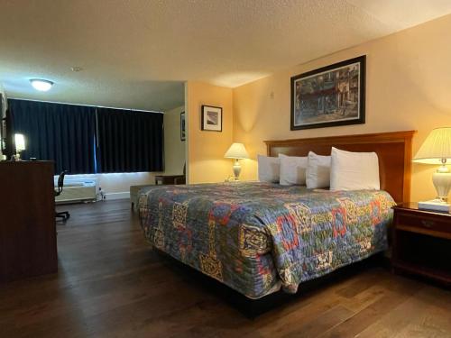 Habitación de hotel con 1 cama y 2 lámparas en Marina Inn Des Moines / SeaTac, en Des Moines