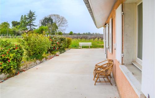 a chair sitting on the porch of a building with a bench at 2 Bedroom Amazing Home In Langon in Langon