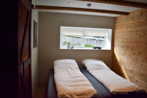 a bed in a room with a window at The Hans Apartment - cosy and special in Klaksvík