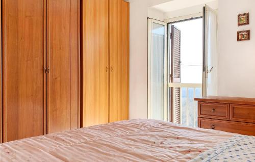 um quarto com uma cama, uma cómoda e uma janela em 2 Bedroom Cozy Apartment In Grotte Di Castro em Grotte di Castro