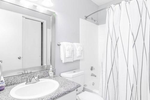 a white bathroom with a sink and a shower at Central 1BR King Bed Suites, Close to Downtown & Domain in Austin