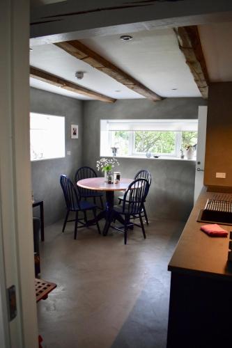 a dining room with a table and chairs and a window at The Hans Apartment - cosy and special in Klaksvík