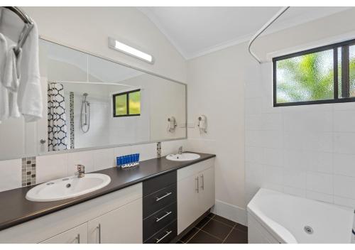 a bathroom with two sinks and a large mirror at Discovery Parks - Rockhampton in Rockhampton