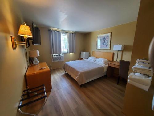 a bedroom with a bed and a desk with a lamp at Alpine Inn in Pagosa Springs