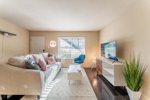 a living room with a couch and a tv at Extended Stay Apartments Next to Downtown in Austin