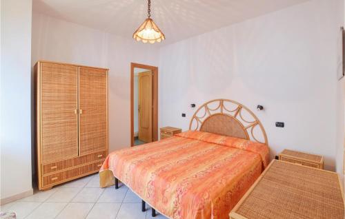 里卡迪的住宿－Awesome Apartment In Ricadi With Wifi，一间卧室配有一张床、一个橱柜和一张桌子