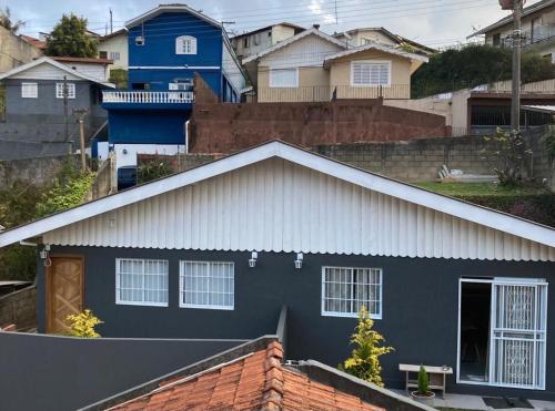 a blue house with a white roof at Apartamento aconchegante próximo Capivari in Campos do Jordão
