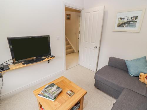 a living room with a couch and a flat screen tv at Church View in Bourton on the Water
