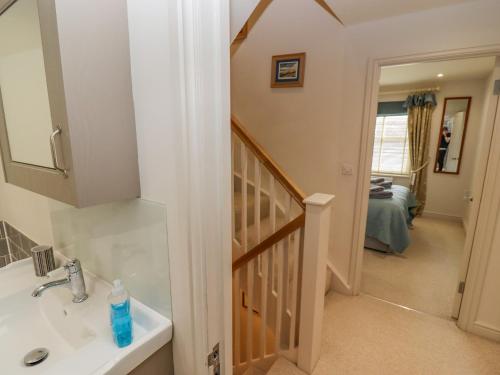 a bathroom with a sink and a stairway at Church View in Bourton on the Water