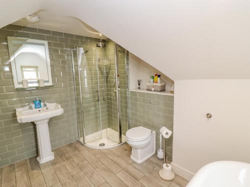 a bathroom with a shower and a toilet and a sink at Church View in Bourton on the Water