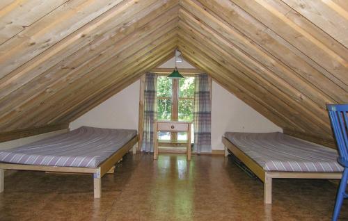 KvänarpにあるAmazing home in Lagan with 3 Bedroomsのベッド2台と窓が備わる屋根裏部屋です。