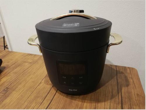 a black slow cooker sitting on top of a wooden table at 海まで3分の貸別荘 Malibu Ichinomiya バレルサウナ ジャグジー BBQ完備 in Ichinomiya