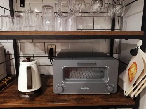 a toaster oven sitting on top of a shelf at 海まで3分の貸別荘 Malibu Ichinomiya バレルサウナ ジャグジー BBQ完備 in Ichinomiya