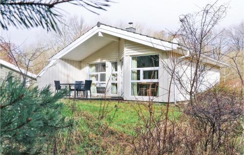 a white house with a table and chairs in the yard at Frische Brise 4 - Dorf 3 in Priwall