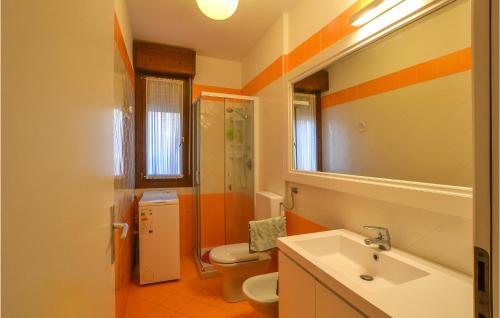 an orange and white bathroom with a sink and a toilet at Cozy Apartment In Rosolina Mare in Rosolina Mare