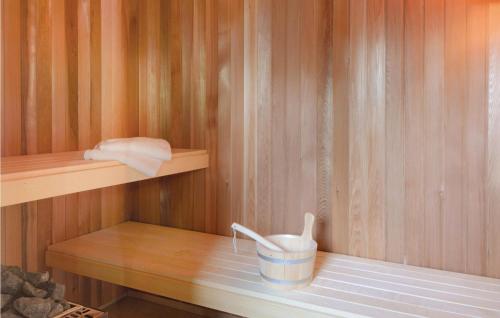 eine kleine Sauna mit einem Eimer und Handtüchern auf einem Regal in der Unterkunft Ferienhaus Dageb�ll 9 in Dagebüll