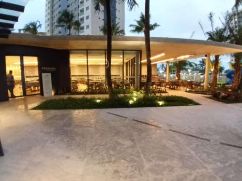 a building with a lot of windows and palm trees at Flat em Salinópolis no Salinas Premium Resort in Salinópolis