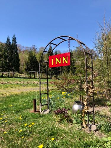 a sign in the middle of a field at 自然の中の古民家ゲストハウスちゃいはな庵 Organic county style classic house Chaihana an in Lake Toya
