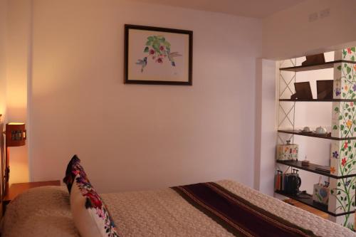 een slaapkamer met een bed en een foto aan de muur bij Casa Rafaela in Cuzco