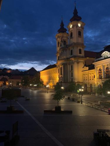 a large building with a clock tower at night at Forst-Ház Apartman in Eger