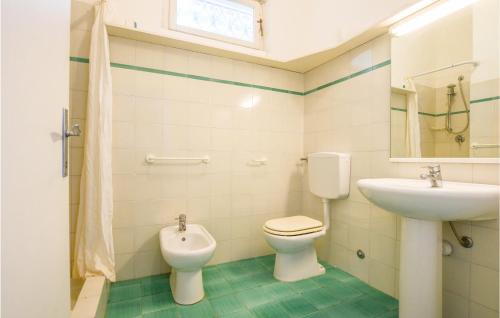 a bathroom with a toilet and a sink and a mirror at Pet Friendly Home In San Piero In Campo With House Sea View in San Piero in Campo