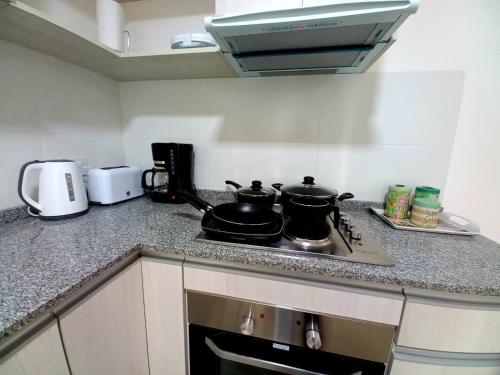 - une cuisine avec 2 casseroles et des poêles sur une cuisinière dans l'établissement Happy Guest Apart 50, à Ushuaia