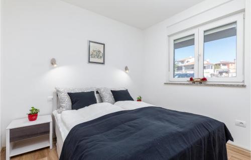een witte slaapkamer met een bed en 2 ramen bij 1 Bedroom Cozy Apartment In Barbariga in Barbariga