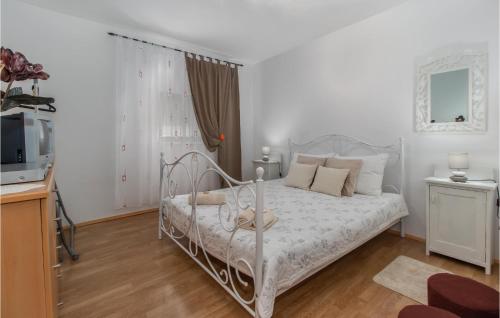 a bedroom with a white bed and a television at Nice Apartment In Smrika With Kitchen in Šmrika