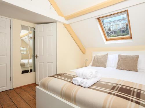 1 dormitorio con 1 cama con toallas en The Retreat, en Dartmouth
