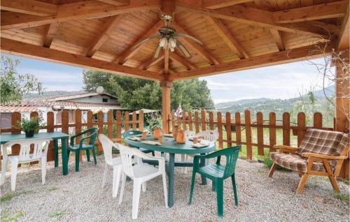 a patio with tables and chairs under a wooden pergola at Rustico Gli Oleandri in Orgosolo