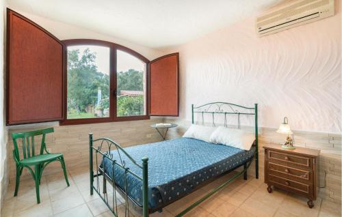 a bedroom with a bed and a chair and a window at Rustico Gli Oleandri in Orgosolo