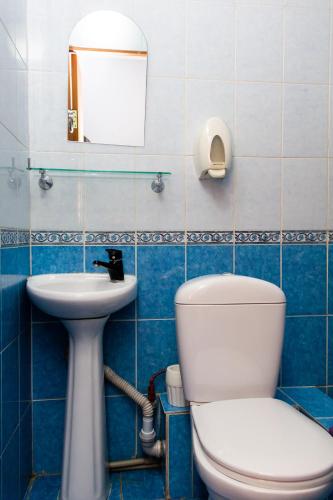 a bathroom with a toilet and a sink at Hotel Tahar in Almaty