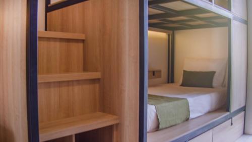 małą sypialnię z łóżkiem i lustrem w obiekcie TRIBAL Coworking Bali w mieście Canggu