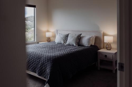 a bedroom with a bed with pillows and a window at Bicheno Gardens in Bicheno
