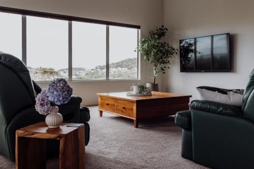 a living room with two chairs and a coffee table at Bicheno Gardens in Bicheno