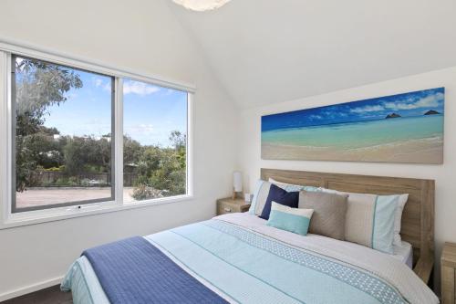 a bedroom with a bed and a large window at Liokai in Anglesea