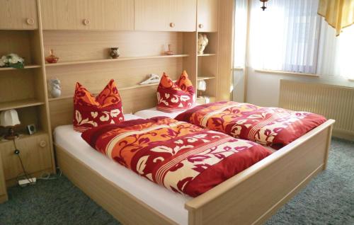 2 Betten mit roten und weißen Kissen in einem Zimmer in der Unterkunft 1 Bedroom Stunning Apartment In Waltershausen-fischb, in Waltershausen