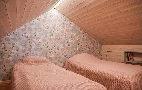 a bedroom with two beds and a wall with flowers at Cozy Home In Söderköping With Kitchen in Söderköping
