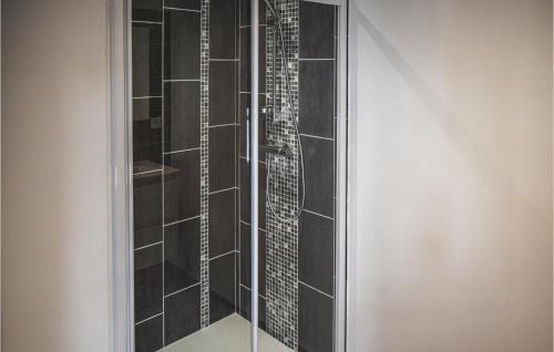 a shower with black tile and a glass wall at 1 Bedroom Awesome Apartment In Noirmoutier-en-lle in Noirmoutier-en-l'lle