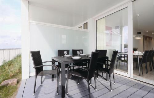 a dining room with a black table and chairs at Priwallpromenade 3, Whg 1 in Priwall