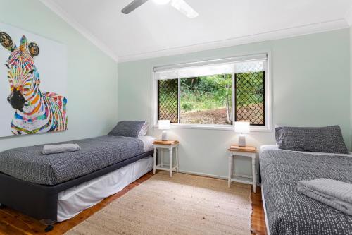 a bedroom with two beds and a zebra painting on the wall at Tree House Toowoomba - Peace & Quiet in tree tops in Preston