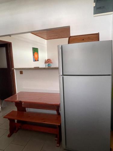 a kitchen with a table and a stainless steel refrigerator at CD House in Fort-de-France