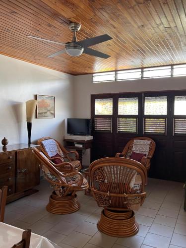 a living room with chairs and a ceiling fan at CD House in Fort-de-France