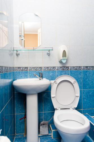 a bathroom with a toilet and a sink and a mirror at Hotel Tahar in Almaty